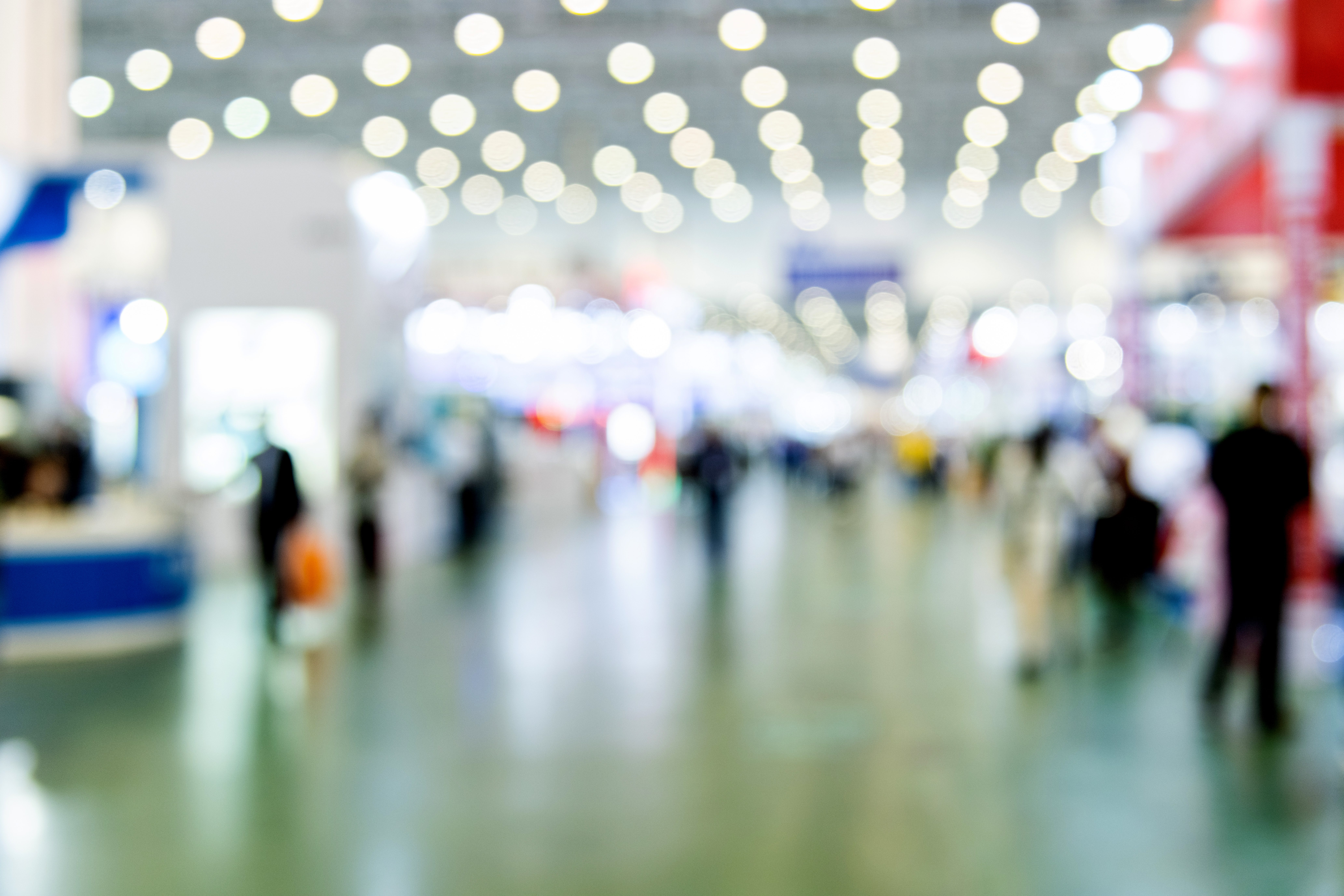 Abstract defocused crowd of people walking in exhibition.